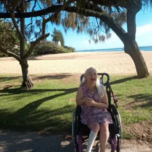 A woman in a wheelchair took part in the LevelUp NDIS Social Community event and had a great time at the beach side.