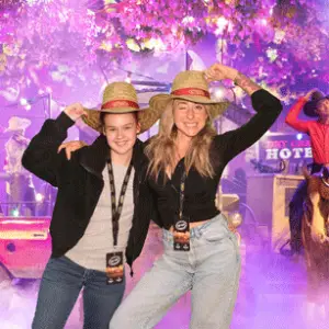 Two women in cowboy hats are smiling for a picture at the LevelUp event.