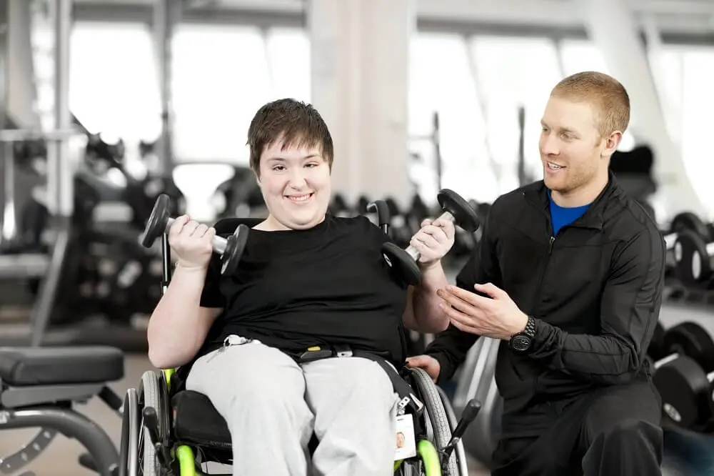 woman with special needs working out at the health club with gym trainer