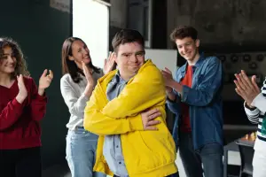 People cheering a man in a yellow hoodie at a LevelUp event.
